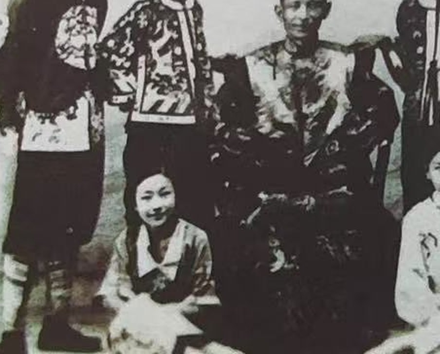 旧照,中坐长者,身后与两侧共六名着绣衣的助手