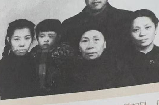 黑白家庭合影五人:后排一位戴圆框眼镜的男子居中,前排左起一名年轻女子怀抱一个幼童,中间一位年长妇人,右侧一位中年女子