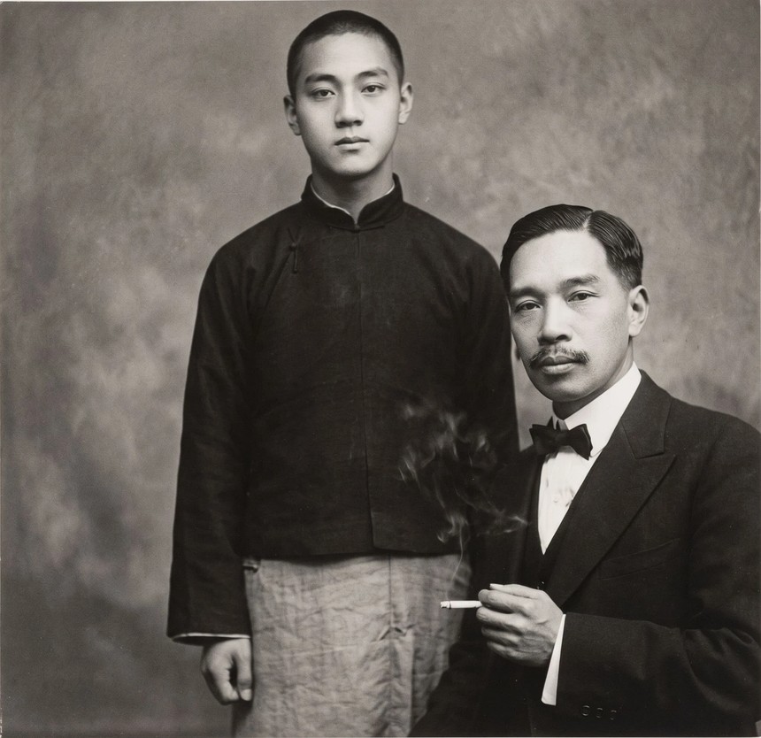 傅志清与次子傅天奇合影:少年着深色对襟上衣立于后,傅志清着西装配领结、指间夹烟在前