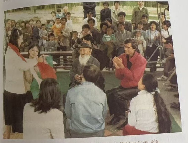 露天场地,围观人群中两人在交流手法