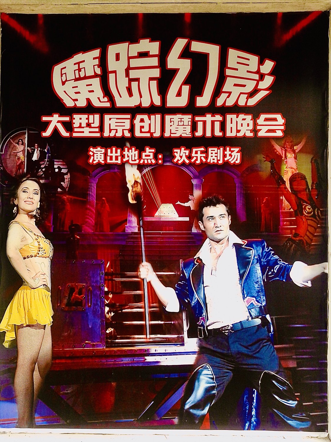 翻拍的演出海报:《魔踪幻影》大型原创魔术晚会,演出地点欢乐剧场;画面左侧一位黄裙女演员,右侧他手持火把